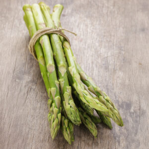 Freshly harvested UC 72 green Asparagus tied with twine on a wooden surface