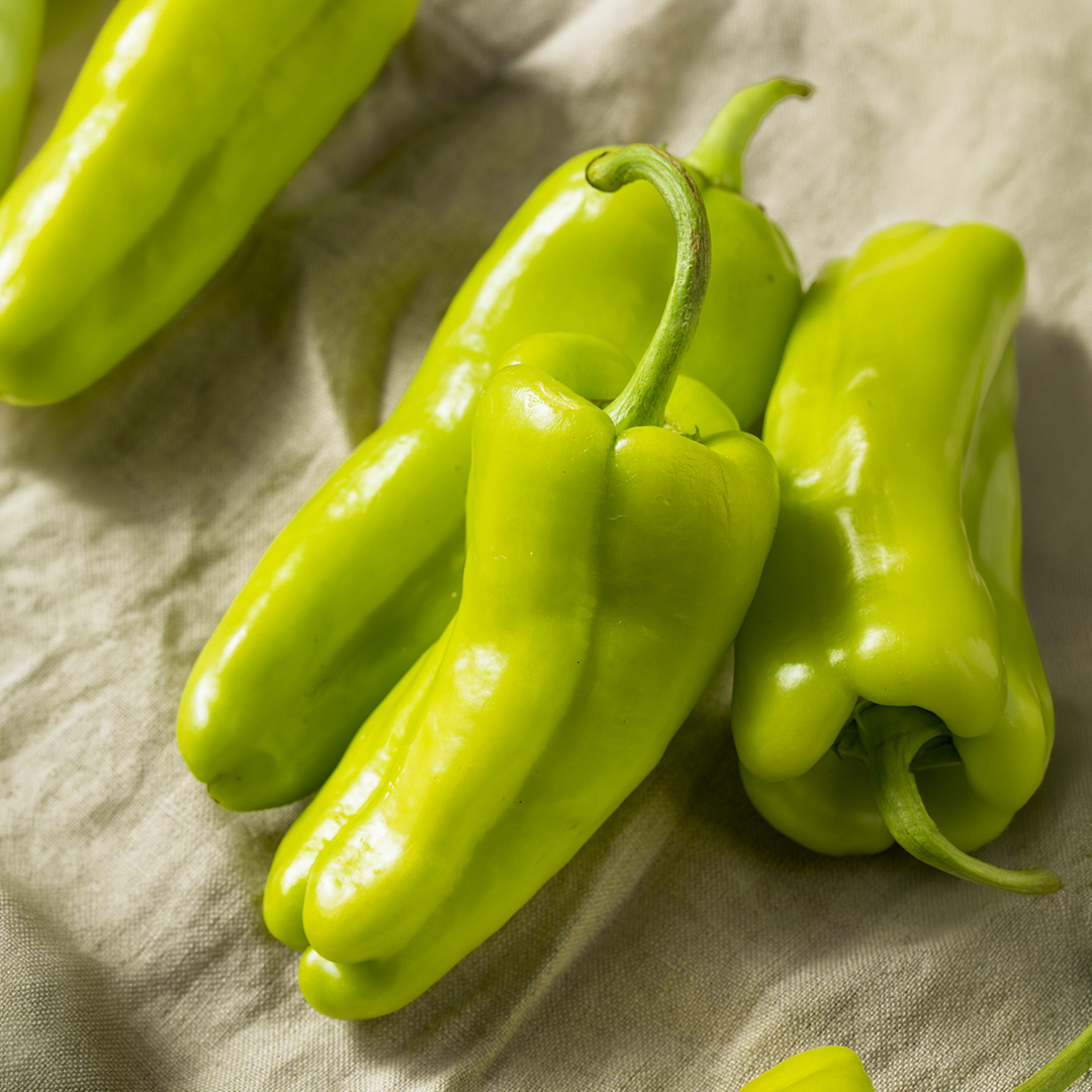 Freshly harvested green sweet Cubanelle Peppers in the kitchen on a cloth
