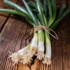 Snow Queen spring onions bunched on a wooden table