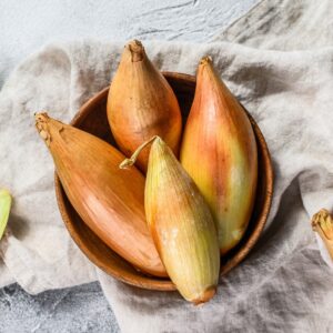Birnformige Onions in a bowl on cloth