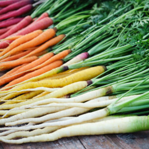 Colorful rainbow carrots on a wooden table. Healthy food. Growing vegetables.