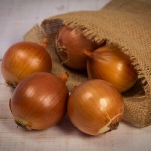Onion in a bag on wooden background