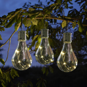 Solar powered garden lightbulbs hanging from a branch in the night