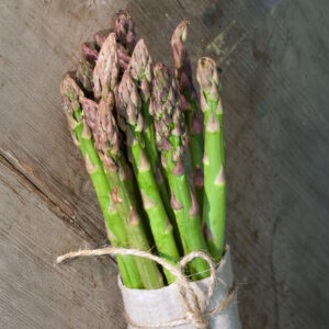 Millennium Asparagus spears freshly harvested and tied with twine on a wooden surface